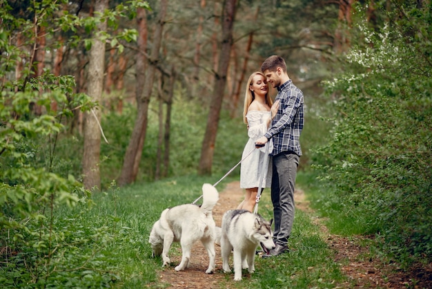 Красивая пара в летнем лесу с собаками