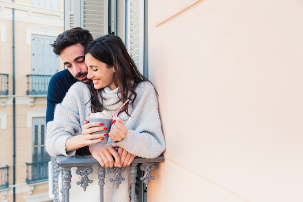 Free photo beautiful couple with beverage on balcony