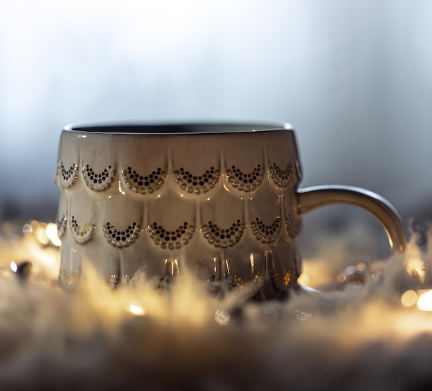 Foto gratuita bella tazza su uno sfondo sfocato al buio con ghirlande