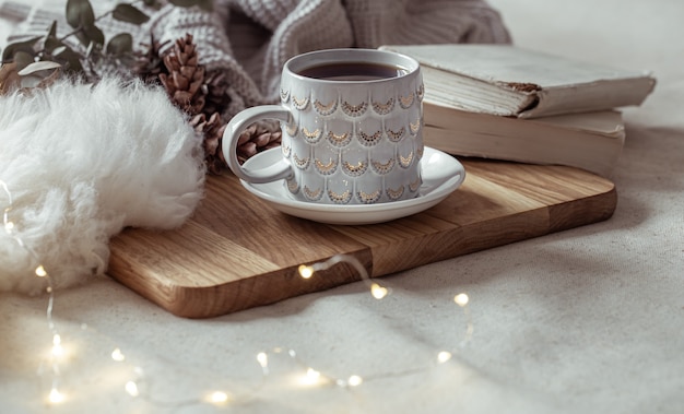 A beautiful cup with a hot drink on a wooden tray. Home comfort concept.