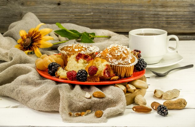 빨간 접시에 나무 벽에 딸기와 아름 다운 컵 케이크