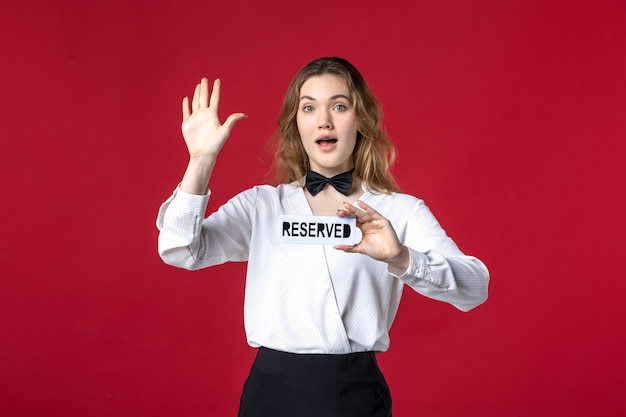 beautiful curious female server butterfly on the neck and holding reserved icon on red background