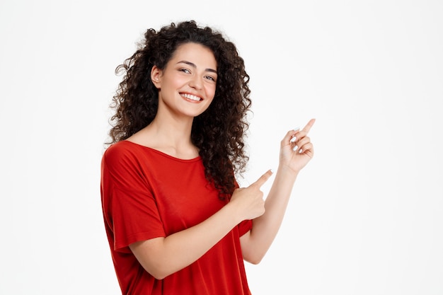 Beautiful curly girl pointing finger