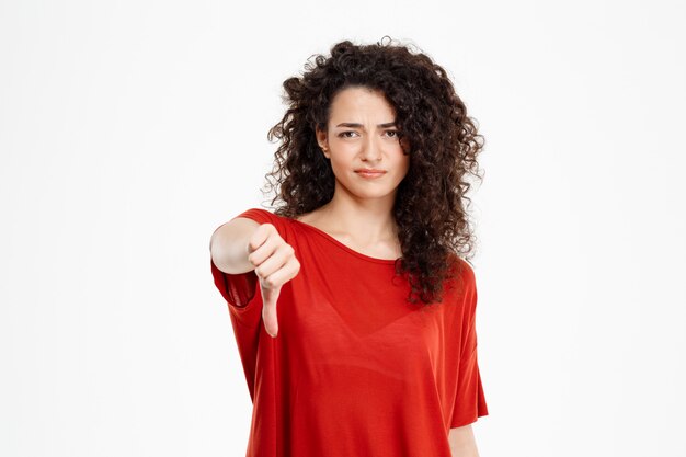 Beautiful curly girl showing thumb down gesture