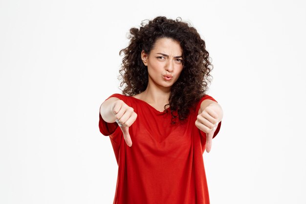 Beautiful curly girl showing thumb down gesture