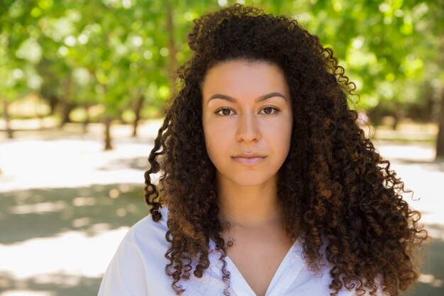 Beautiful curly woman standing and looking at camera