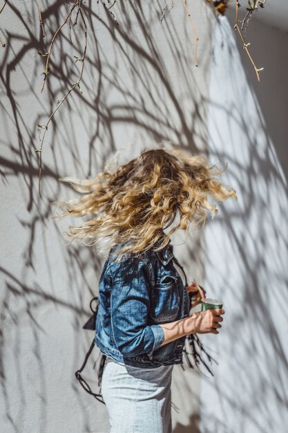 beautiful curly young woman outdoors walking and drinking coffee. 