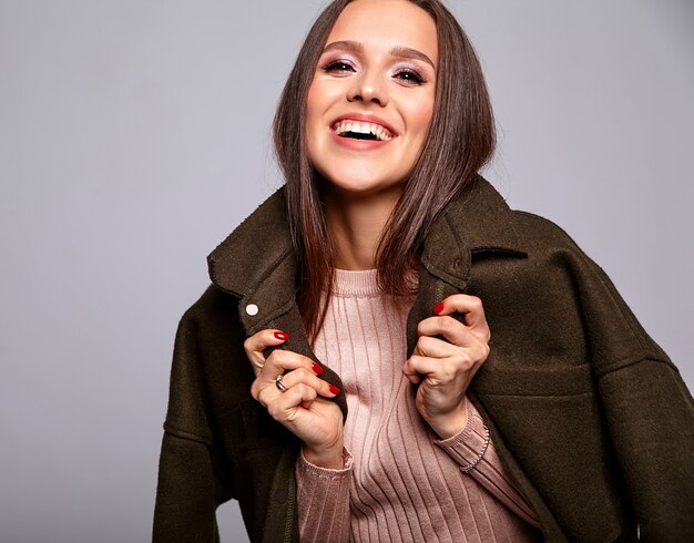 beautiful cute brunette model in casual beige warm sweater and dark coat