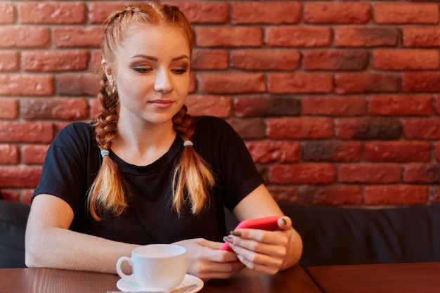 カフェで美しいかわいい白人の若い女性