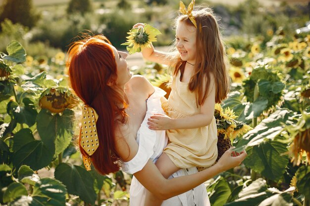 Beautiful and cute family in a field wirh sunflowers