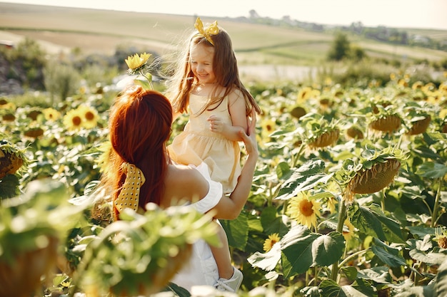 Beautiful and cute family in a field wirh sunflowers