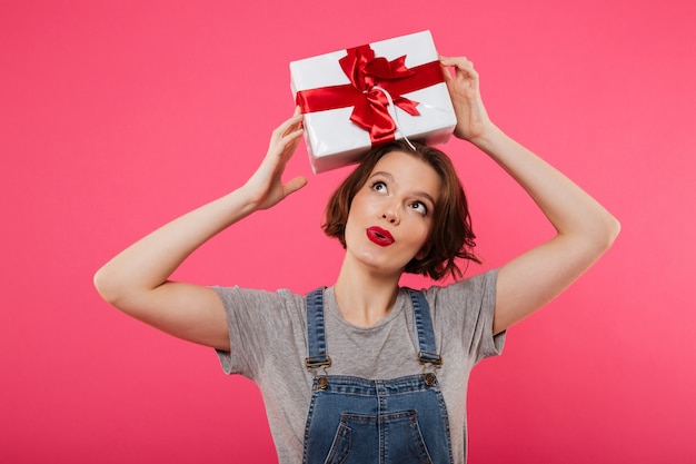 Beautiful cute young woman holding gift box.