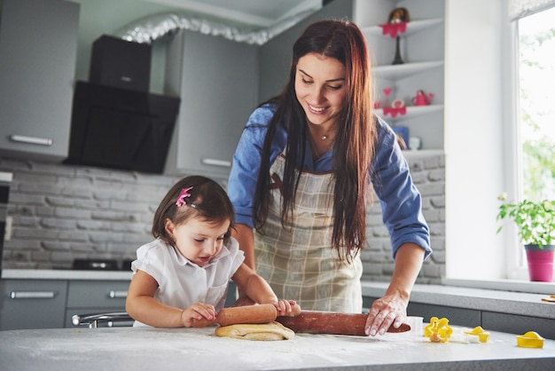 A beautiful daughter with her mother cooking in the kitchen