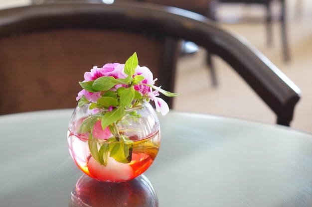 무료 사진 방에있는 테이블에 유리 꽃병에 핑크 꽃의 아름다운 장식