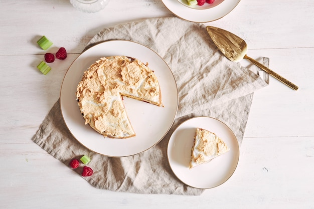 Beautiful and delicious raspberry and rhubarb cake with ingredients on a table