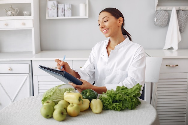 Beautiful doctor in a kitchen with vegetables