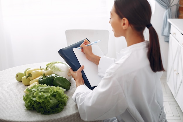 Beautiful doctor in a kitchen with vegetables