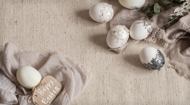 Красивые пасхальные яйца разбросаны по фактурной ткани. Концепция пасхального декора.