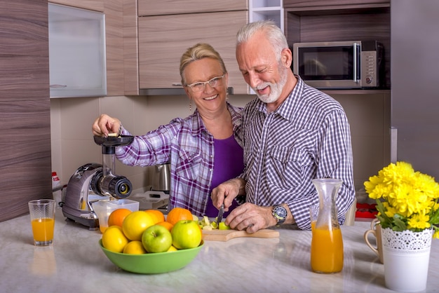 Beautiful elderly couple cooking in the kitchen with each other