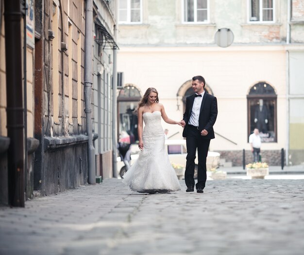 美しいエレガントなカップル、通りを歩く