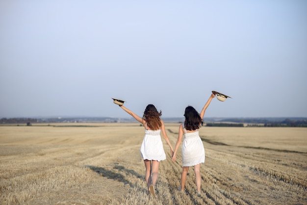 Beautiful elegant girls in a autumn wheat field