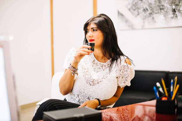 Beautiful elegant model with coffee in office