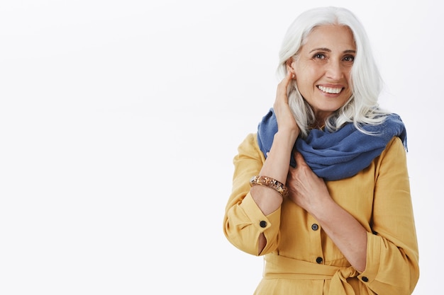 Beautiful elegant old woman with grey hair in stylish outfit smiling