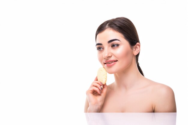 Beautiful elegant woman with a sponge in her hands with bare shoulders skin care isolated