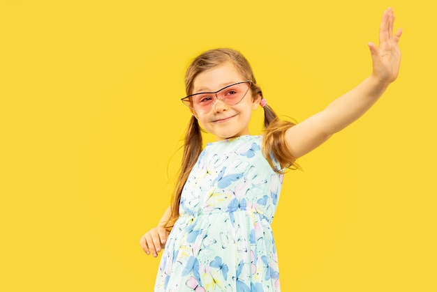 Beautiful emotional little girl isolated on yellow