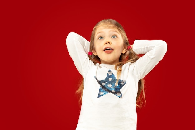 Free photo beautiful emotional little girl on red