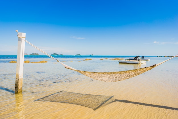 休日の休暇のための熱帯のビーチ海海の周りの美しい空のハンモック