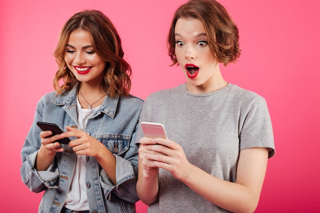 Beautiful excited ladies friends chatting by phones.