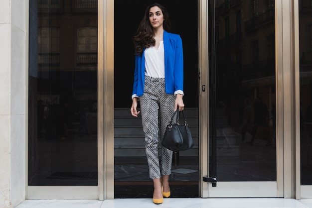 Beautiful executive with blue jacket and black handbag