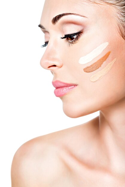 Beautiful face of  young woman with cosmetic foundation on a skin.   Beauty treatment concept