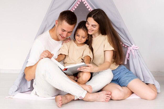 Красивая семья, весело проводящая время в палатке