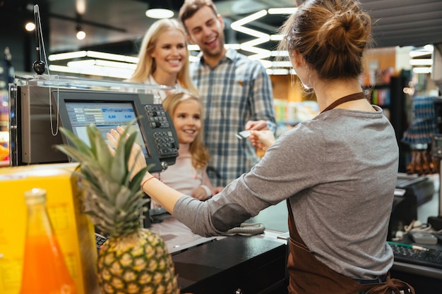 Beautiful family paying for their groceries