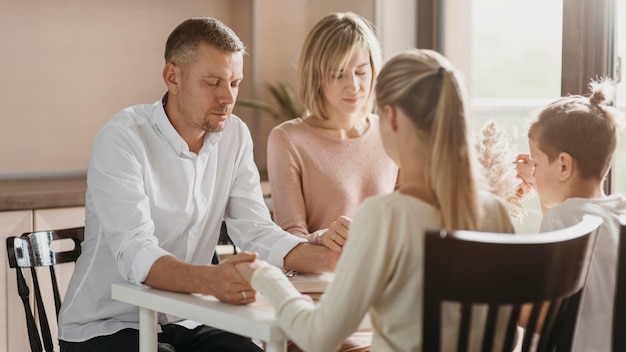 Beautiful family praying before eating