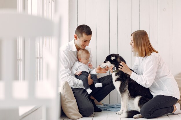 Красивая семья проводит время в спальне с собакой