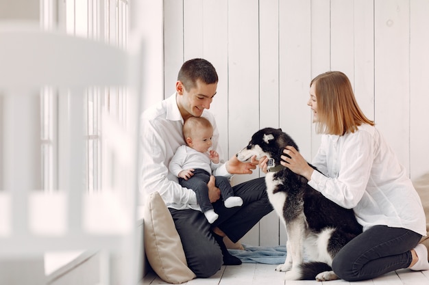 Beautiful family spend time in a bedroom with a dog