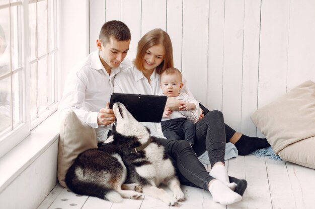 Красивая семья проводит время в спальне с планшетом