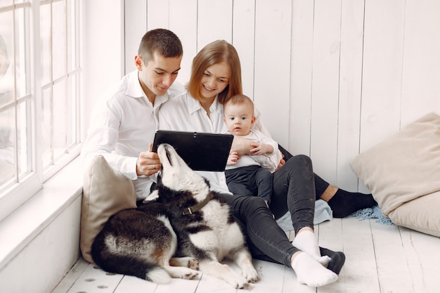 Beautiful family spend time in a bedroom with a tablet