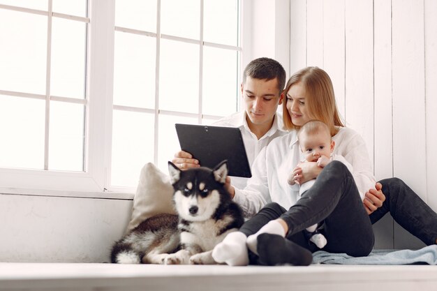 Beautiful family spend time in a bedroom with a tablet
