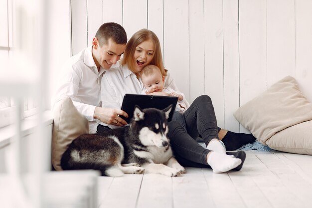 Красивая семья проводит время в спальне с планшетом