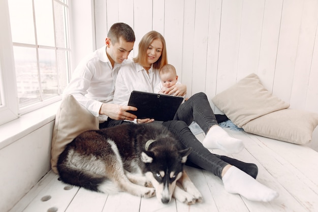 Beautiful family spend time in a bedroom with a tablet