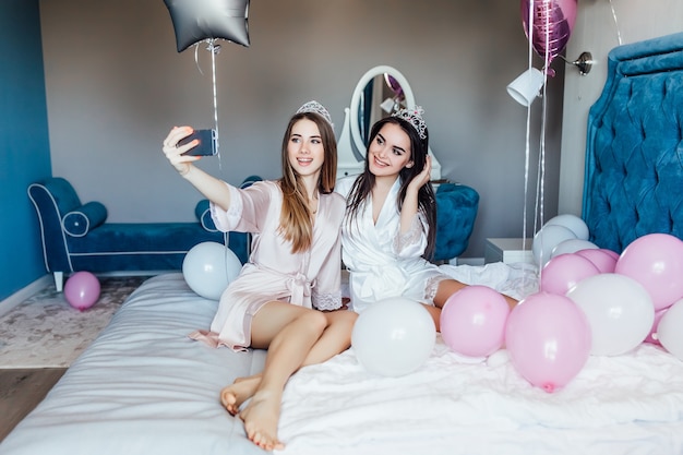 Beautiful fancy ladies holds beverage with balloons