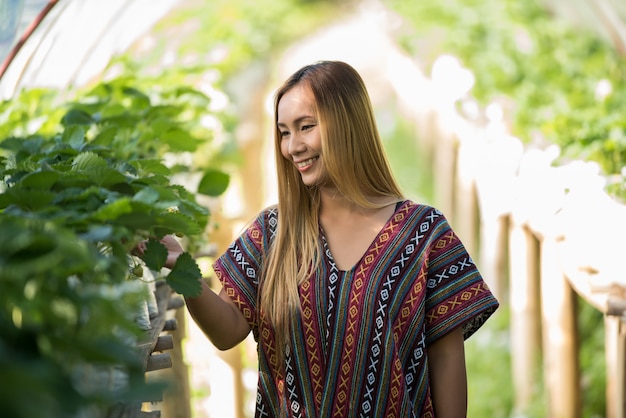 Free photo beautiful farmer woman checking strawberry farm