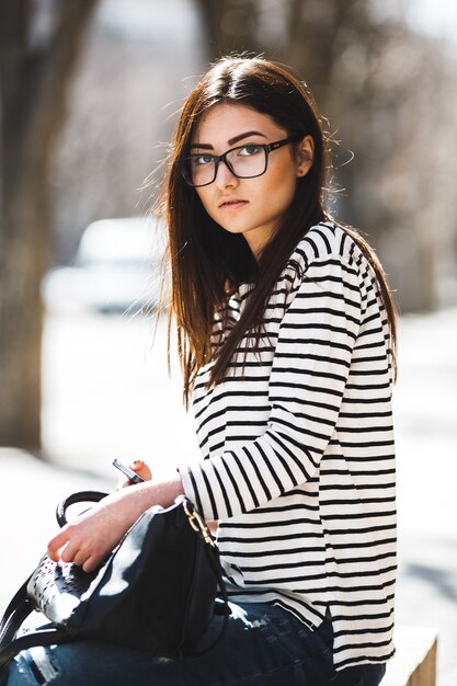 Beautiful fashion model in glasses sits