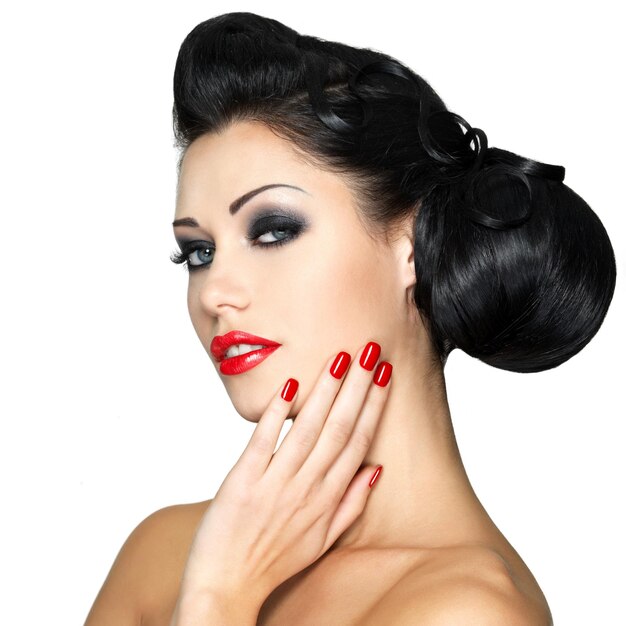赤い唇、爪、創造的な髪型を持つ美しいファッションの女性-白い壁に分離