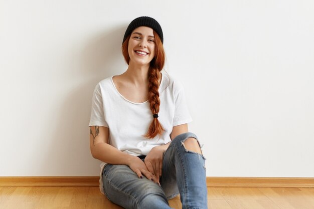 Beautiful fashionable young woman with happy smile wearing stylish hat