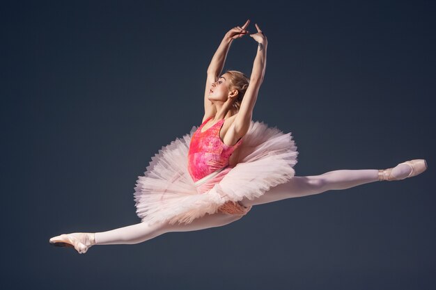 Beautiful female ballet dancer on a grey background